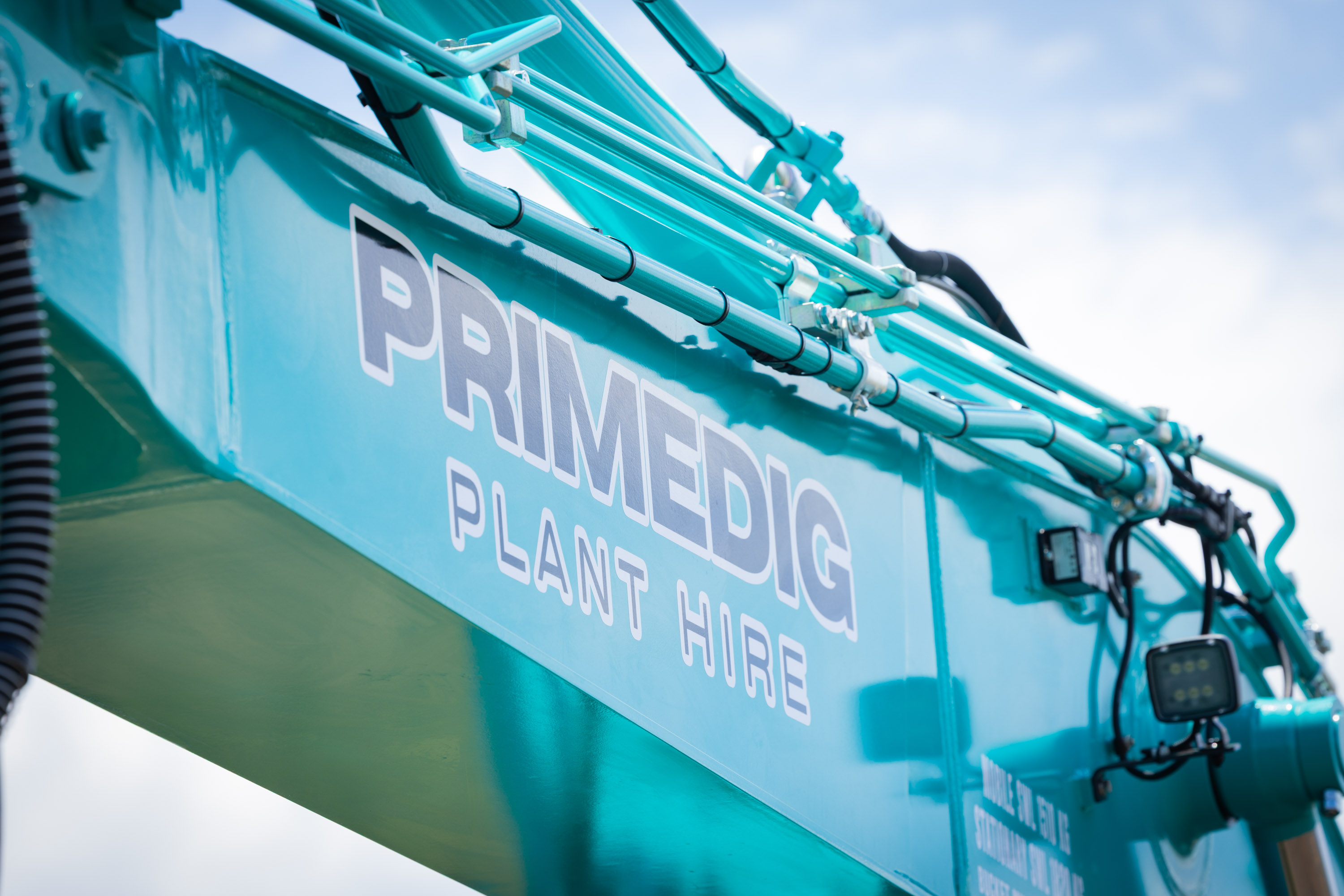 PrimeDig Plant Hire branding on the boom of a Kobelco excavator
